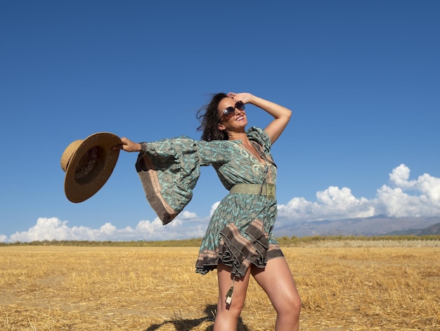 Lachende jonge brunette in zonnig gouden veld