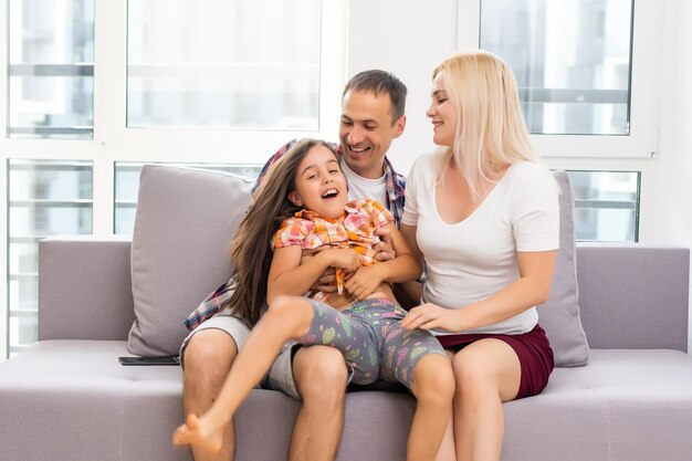 Lachende jonge ouders en hun kind zijn erg blij, ze zijn thuis