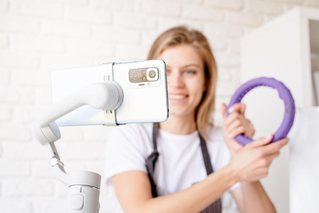 Lachende jonge vrouw blogger influencer thuis streaming over hulpmiddelen voor huisdierenverzorging Vrouw spreken over hondenvoer kijken naar camera praten maken video-chat Close up van smartphone