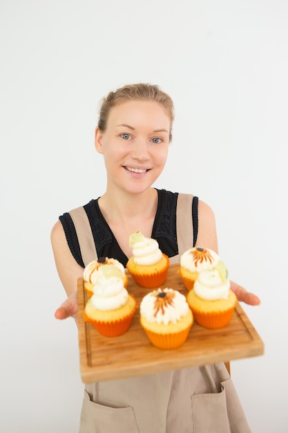 Lachende jonge vrouw met Bureau met Cupcakes