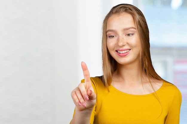 Lachende jonge vrouw wijzend