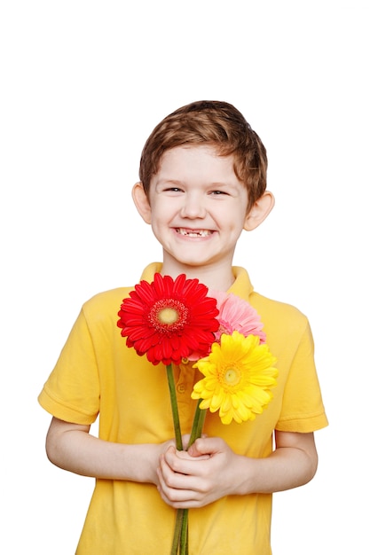 Lachende jongen met boeketgerberabloemen.