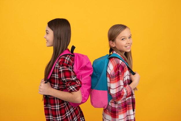 Lachende kinderen in casual geruit overhemd dragen rugzak september