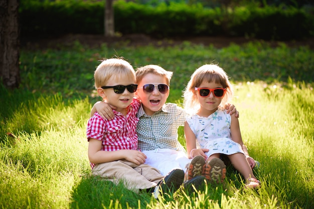 Lachende kinderen in de tuin in zonnebril