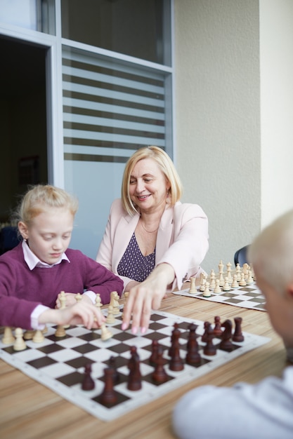 Lachende leraar kinderen helpen