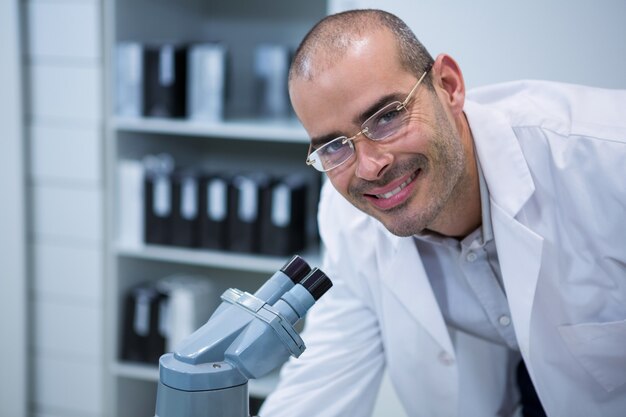 Foto lachende mannelijke optometrist met microscoop