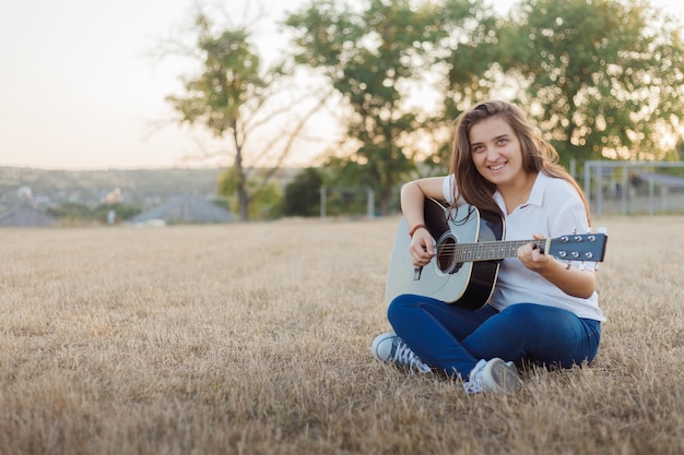 Lachende meisje zingen op gitaar