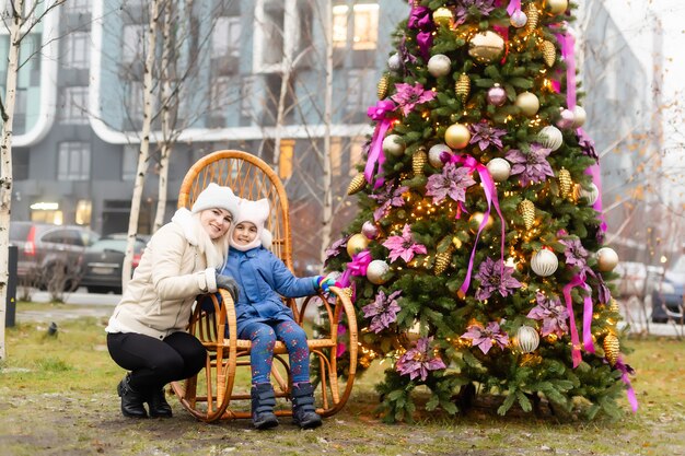 Lachende moeder en dochter bij de kerstboom