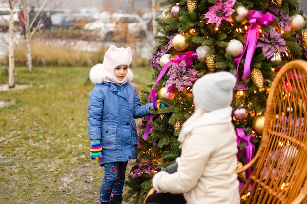 Lachende moeder en dochter bij de kerstboom