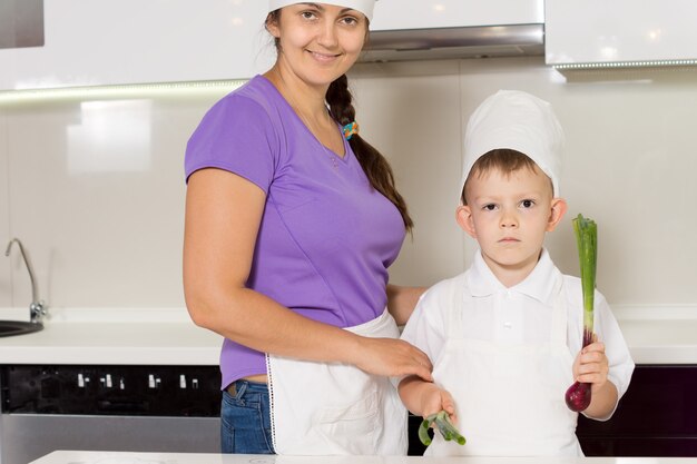 Lachende moeder en zoon in koksoutfits