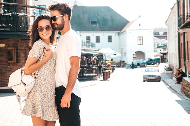 Lachende mooie vrouw en haar knappe vriendje vrouw in casual zomerkleren gelukkige vrolijke familie vrouw plezier paar poseren op de straat achtergrond in zonnebril knuffelen elkaar