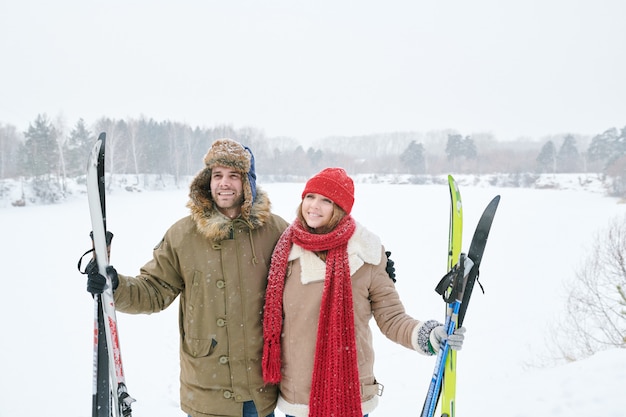 Lachende paar holding ski's