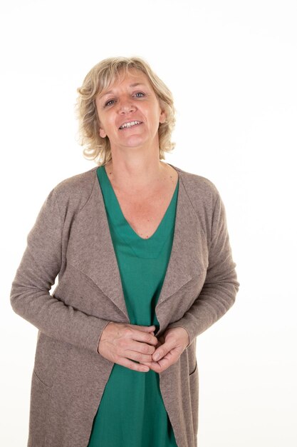 Foto lachende senior vrouw blonde volwassen in groene top en beige vest op witte achtergrond