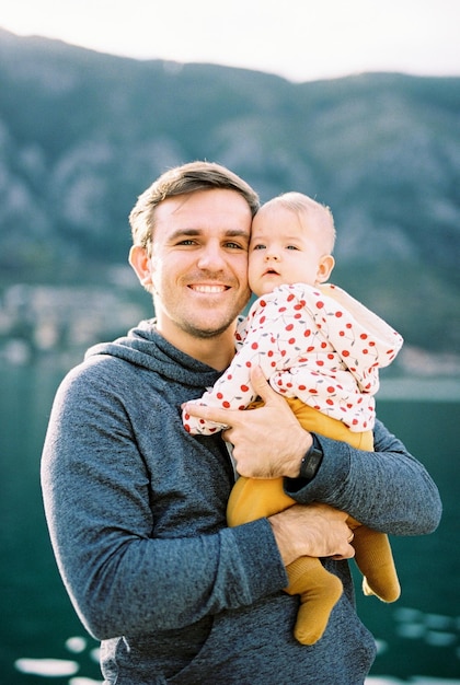 Lachende vader knuffelt de baby in zijn armen Portret