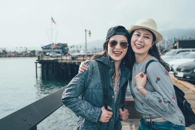 Lachende vrienden staan bij de oceaan Stearns Wharf