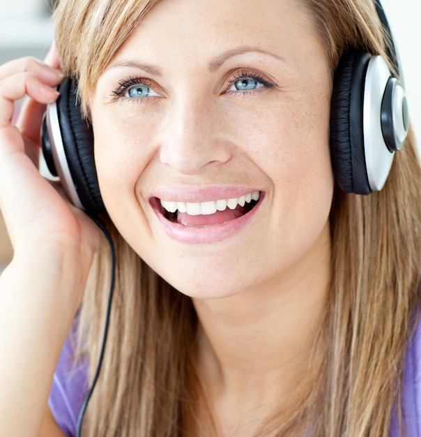 Lachende vrouw die aan muziek luistert