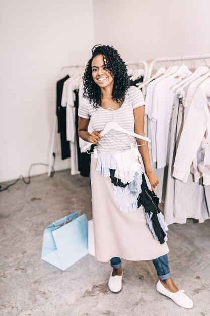 Lachende vrouw die trendy rok in winkel probeert