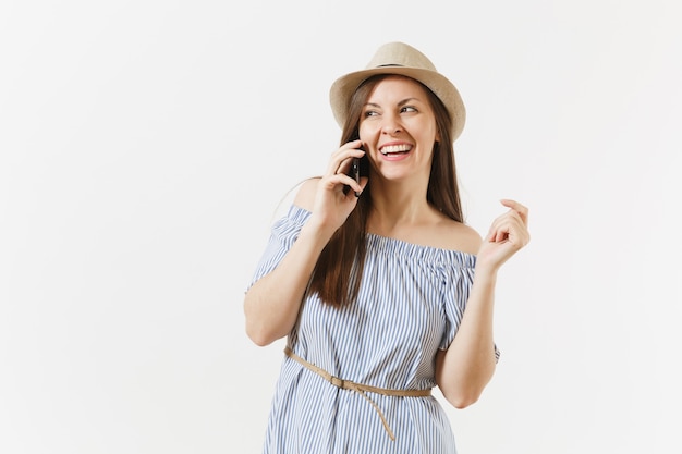 Lachende vrouw gekleed blauwe jurk, hoed praten op mobiele telefoon, aangenaam gesprek voeren geïsoleerd op een witte achtergrond. Mensen, oprechte emoties, lifestyle concept. Reclame gebied. Ruimte kopiëren.