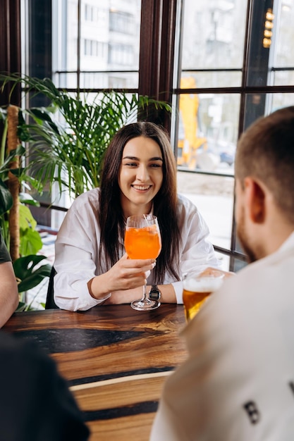 Lachende vrouw genieten van cocktail in restaurant tijdens rust met vriendenfeest en feestconcept