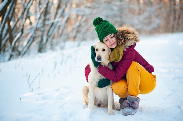 Lachende vrouw haar hond golden retriever knuffelen