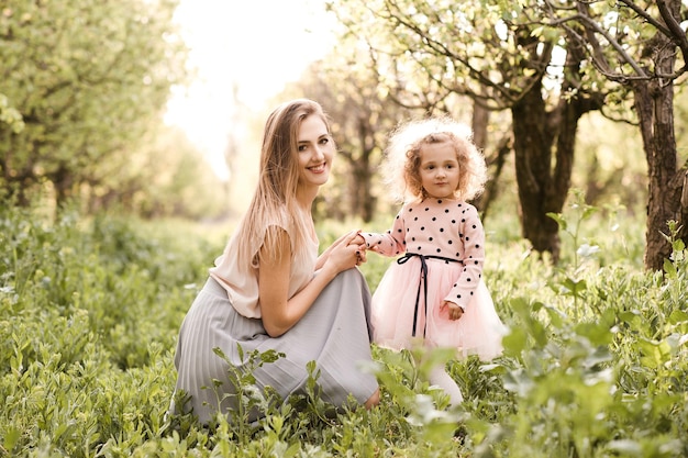 Lachende vrouw met babymeisje poseren in weide buitenshuis