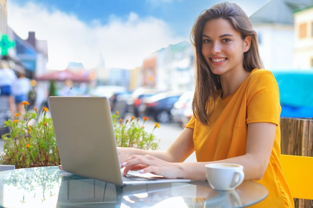 Lachende vrouw met behulp van laptop in café Concept van ondernemer zakenvrouw freelance werknemer