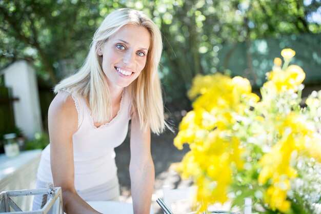 Foto lachende vrouw met bloemen buitenshuis