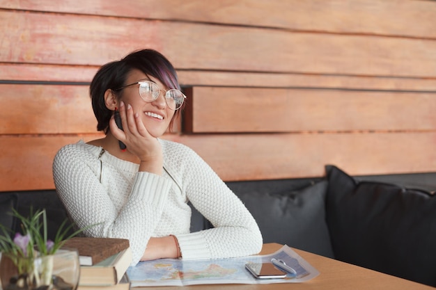 Lachende vrouw met kaart aan tafel