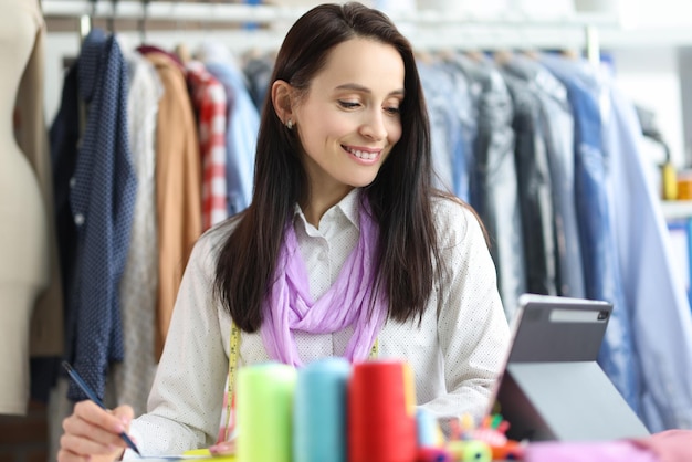 Lachende vrouw stylist ontwerper op werkplek in atelier