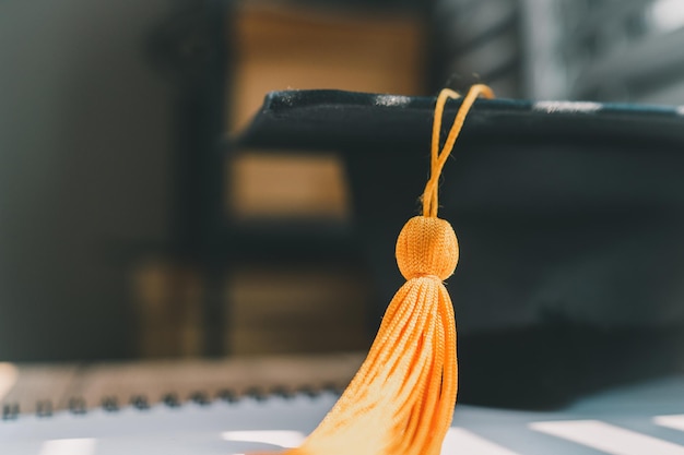 Lack graduation cap university level and a notebook on a wooden table graduation concept