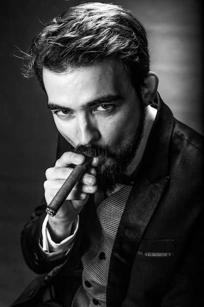 lack and white portrait of bearded smoking gentleman in a suit