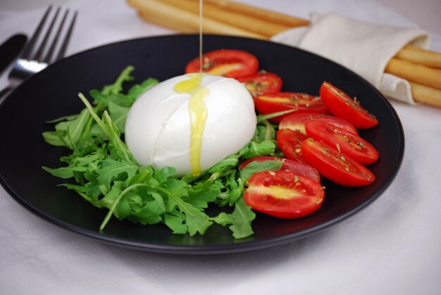 Lactose-free mozzarella with rocket oil and tomatoes