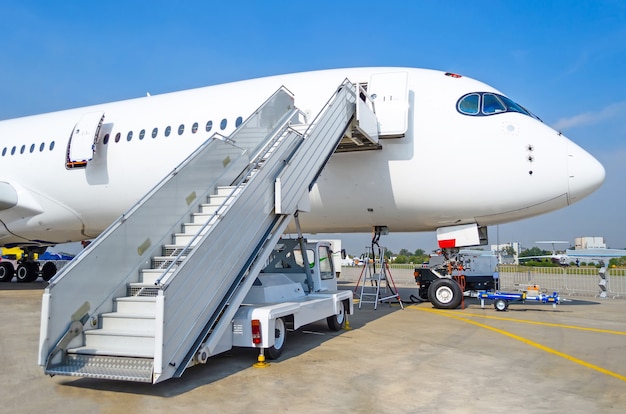 Ladder to the entrance of the aircraft in the parking lot at\
the airport, view the nose of the aircraft.