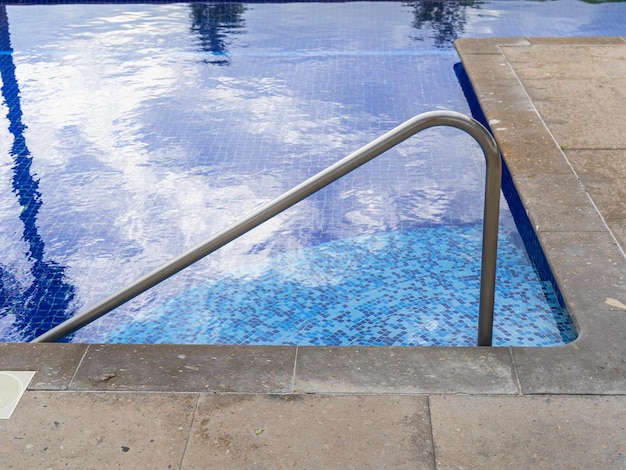 Ladder stainless handrails for descent into swimming pool.