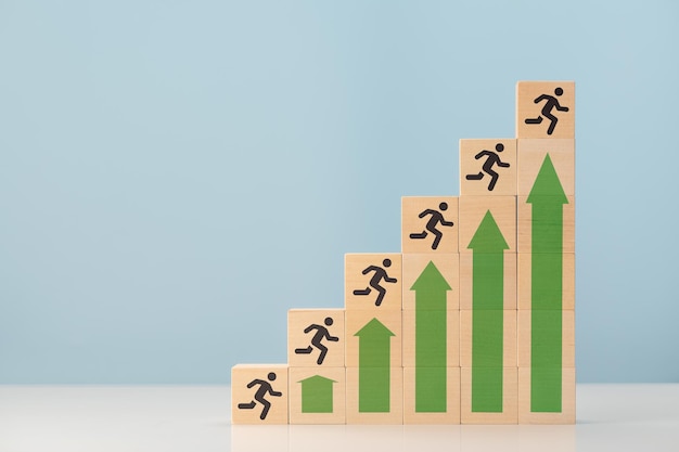 Scala del successo uomo di successo aziendale che corre per salire le scale frecce che mostrano la crescita e la silhouette dell'uomo sullo spazio della copia di cubi di legno