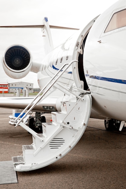 Ladderval en open deur naar zakenjetvliegtuig