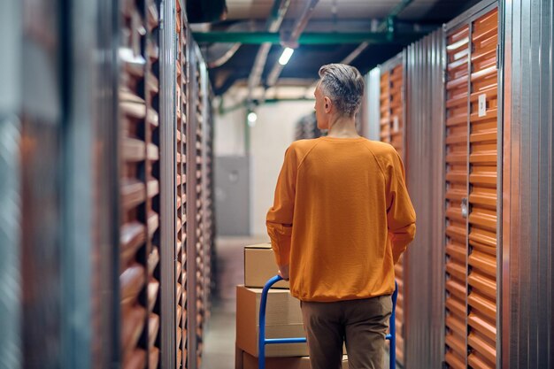 Lader die de platformwagen langs zeecontainers rijdt