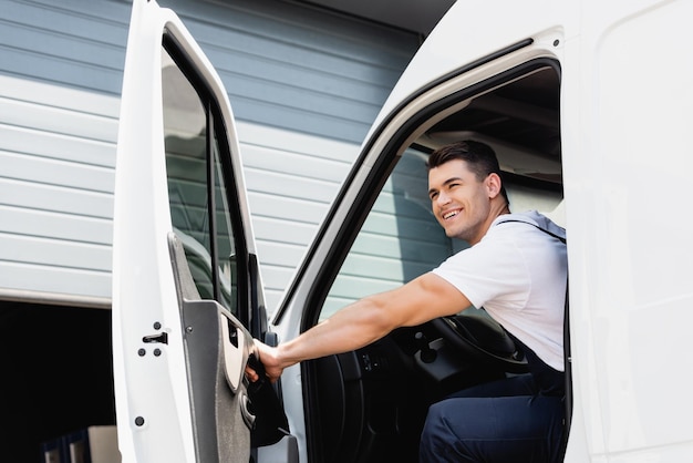 Lader in uniform die wegkijkt terwijl hij in een vrachtwagen zit