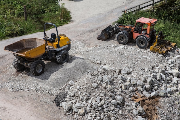 Lader kleine bulldozer die zich op bouwgebied beweegt