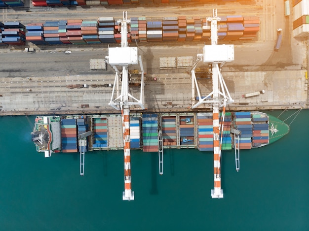 Ladingscontainer in de haven van de dokkenwerf met vrachtschip die grote tank voor de uitvoerconcept laden.