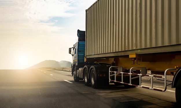 Ladingsvrachtwagen op wegweg met container, vervoer op de snelweg. Vrachtwagenonduidelijk beeld aan zachte nadruk