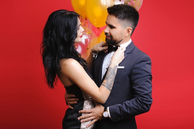 Lady adjusting bow tie of her man smiling