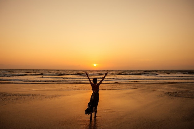 Леди одна на закате на пляже встречается с пляжем Гоа в Индии