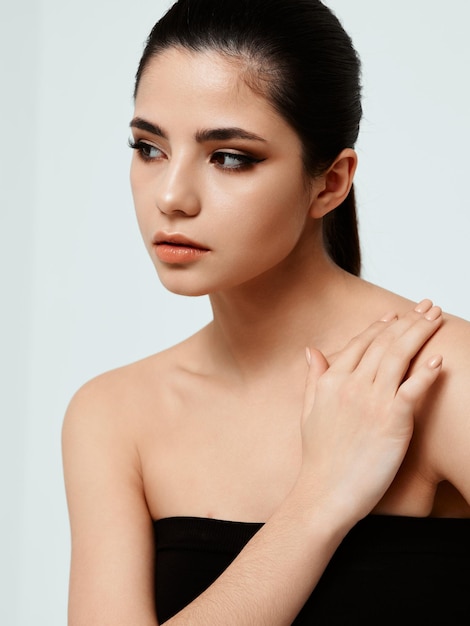 Lady in black dress put her hand on her shoulder and make up awnings