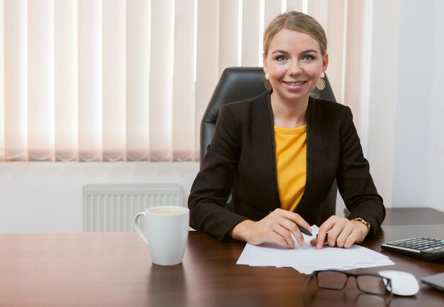 Lady boss looking directly at the camera while sitting in her office