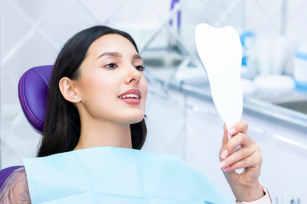 Photo lady checks her teeth in the mirror.