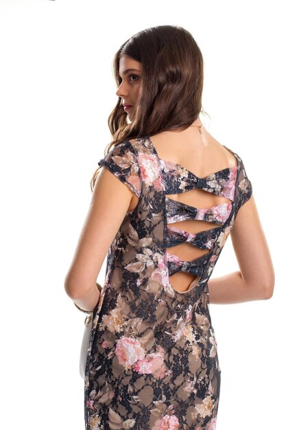 Lady in dark floral dress. Dress with cutouts on back. Trendy short sleeve dress. Model wears exclusive clothes.