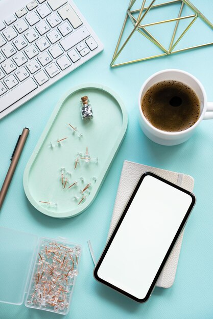 Lady freelancer's home pastel blue workplace cup of coffee and smartphone mockup on tabletop