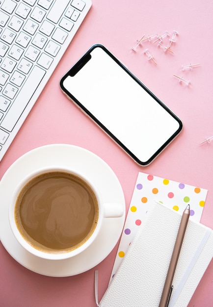 Lady freelancer's home pastel pink workplace cup of coffee and smartphone mockup