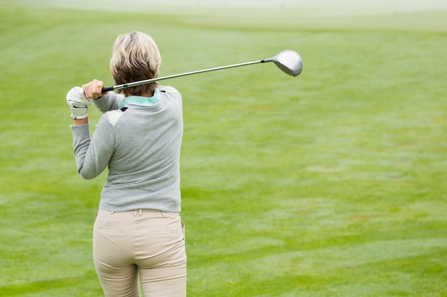 Photo lady golfer teeing off for the day